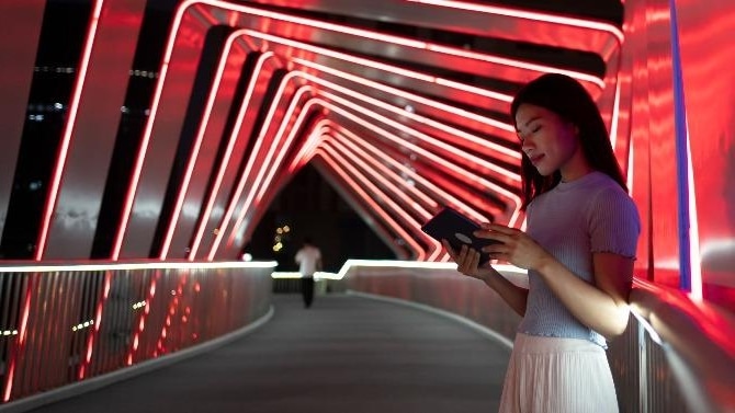 Frau mit Tablet auf Brücke